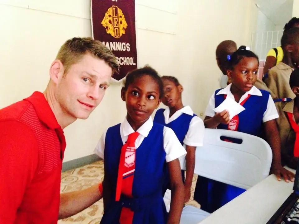 Dr. Johnson working at an Eyecare mission with children around him